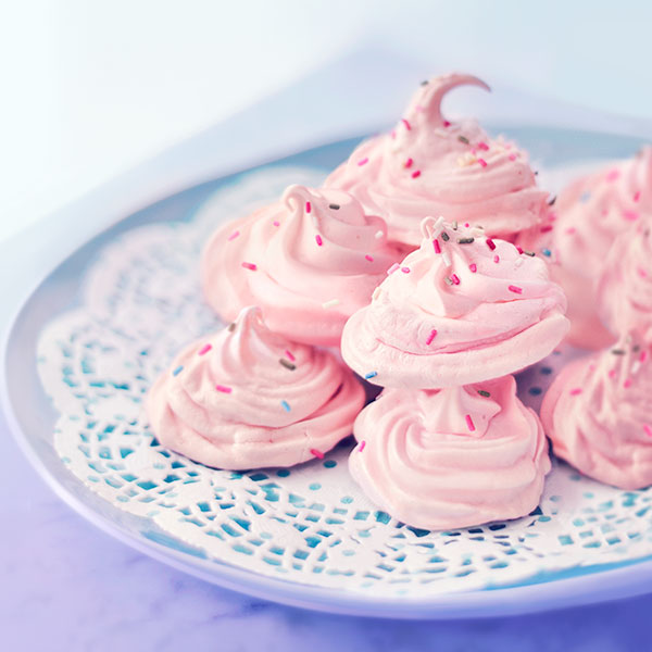 Plate of pink and white peppermint meringue cookies.