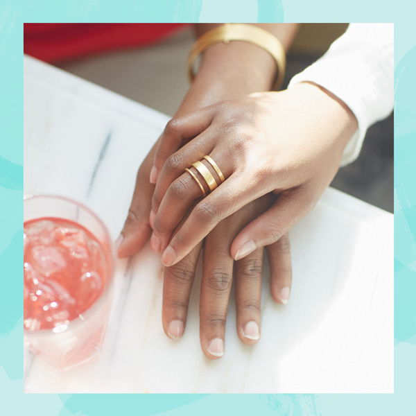 Two hands holding with drink on table.