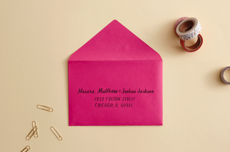 envelope on desk with pen that reads