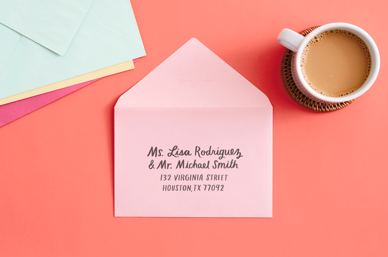 envelope on desk with pen that reads