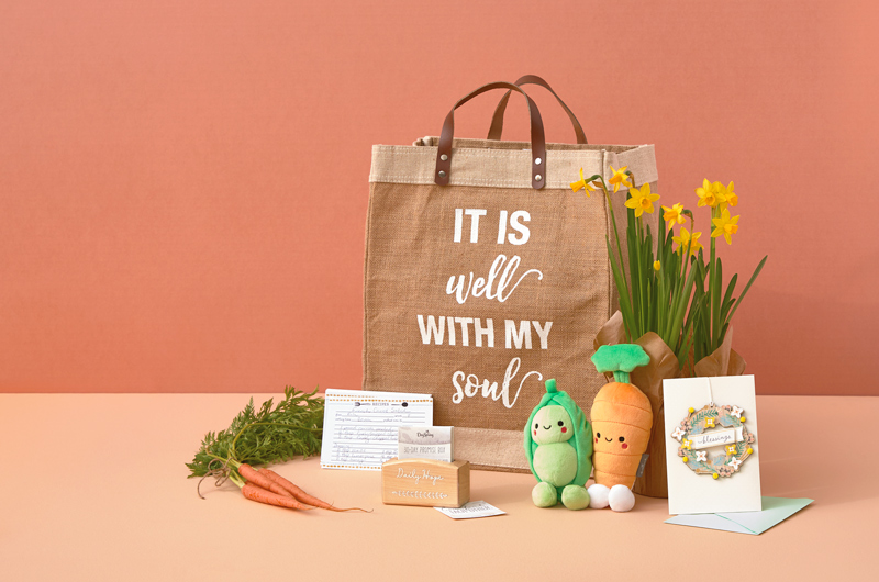 A farmer's market themed Easter care package with a pea and carrot Better Together plush set, potted narcissus flowers, a tote bag that reads,