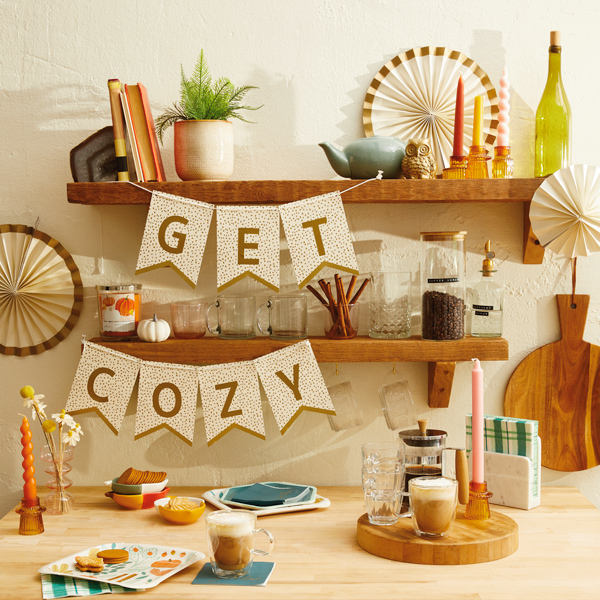 A bar set up with fall drinks like pumpkin spiced lattes and hot buttered rum, with a banner that reads