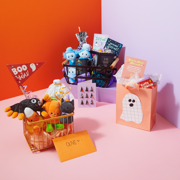 A trio of assembled Halloween boo bags and baskets; one is for fans of Disney The Haunted Mansion, another is meant for small children, and the last is made for adults and includes a bottle of wine.