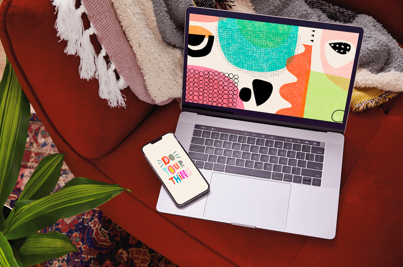 A laptop screen displaying the free January downloadable desktop wallpaper, with a mobile phone displaying the free downloadable mobile wallpaper lying nearby.