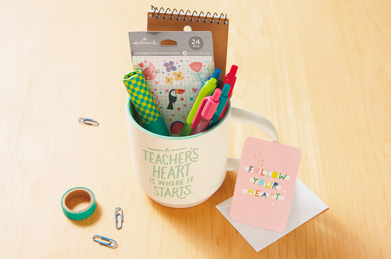 A mug gift bundle for a teacher that includes a white ceramic mug that reads,