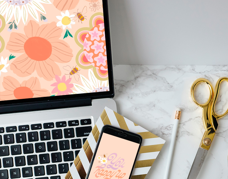 A laptop screen displaying the free September downloadable desktop wallpaper, with a mobile phone displaying the free downloadable mobile wallpaper lying nearby.