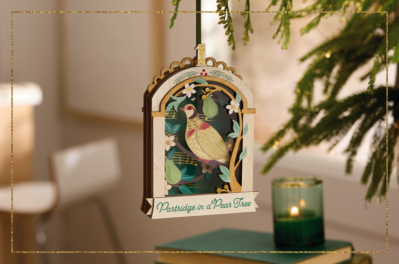 A Keepsake Ornament made of wood and paper with a three-dimensional effect; the ornament is the first in a new series called