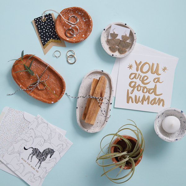 An assortment of different handmade clay bowls and a card that says,